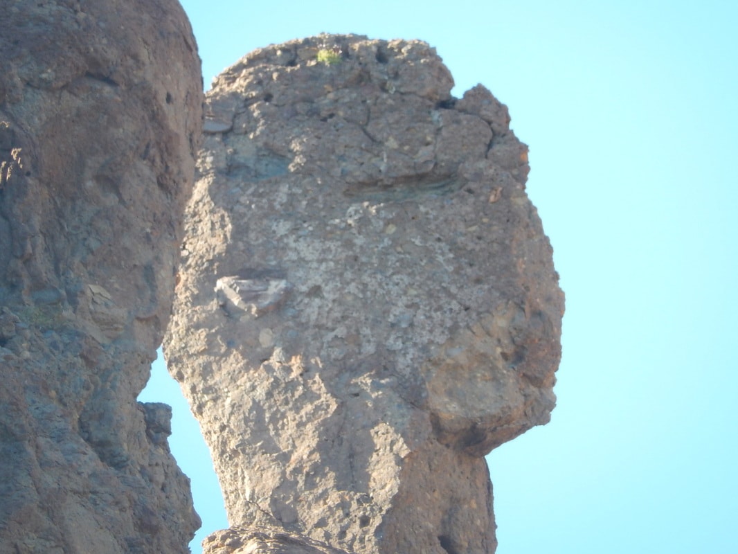 Dramatic rock spire formation rising against a blue sky on a Loreto island snorkeling tour